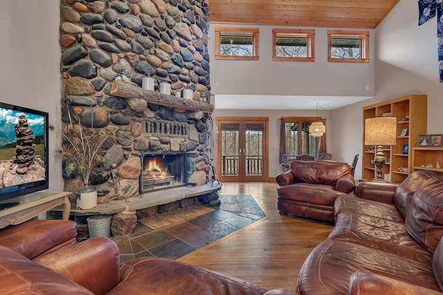 living area with wooden ceiling, a fireplace, high vaulted ceiling, and wood finished floors