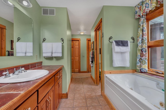 full bathroom with vanity, tile patterned floors, baseboards, visible vents, and a bath