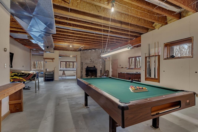 game room with concrete floors, pool table, and a fireplace