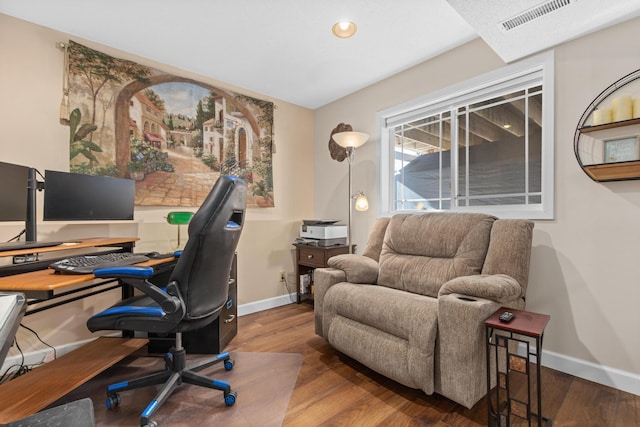 home office with wood finished floors, visible vents, and baseboards