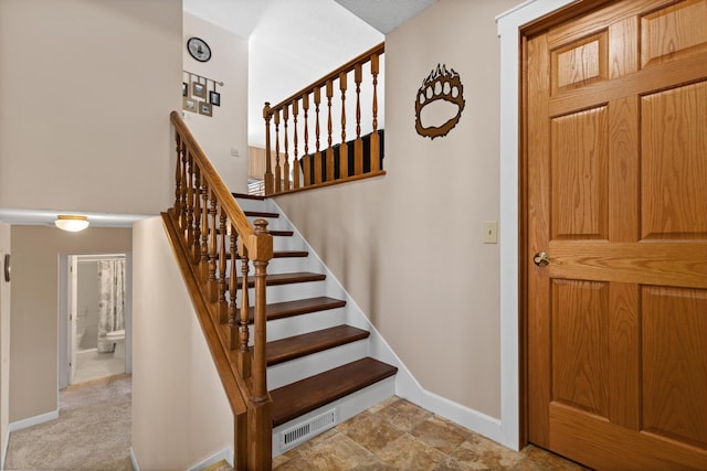 staircase featuring visible vents and baseboards