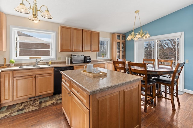 kitchen with dishwasher, dark wood-type flooring, an inviting chandelier, and a sink