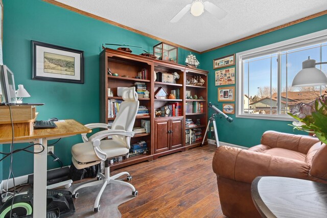 office area with baseboards, ornamental molding, a textured ceiling, a ceiling fan, and dark wood-style flooring