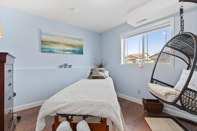 bedroom with dark wood-style floors, visible vents, and baseboards