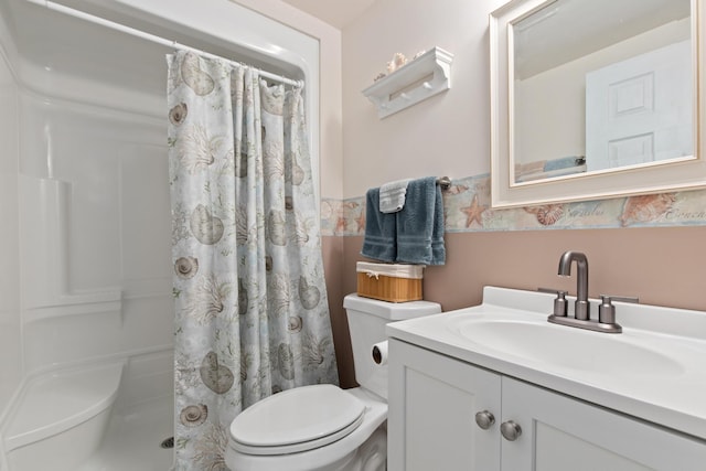 bathroom featuring a shower with shower curtain, toilet, wainscoting, and vanity