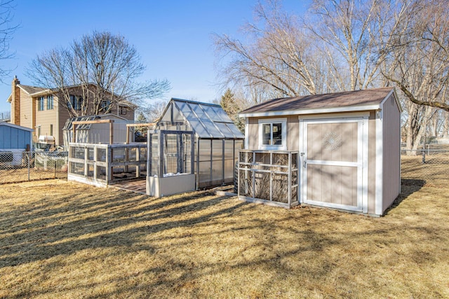 view of yard with an outbuilding, a storage unit, fence, and an exterior structure