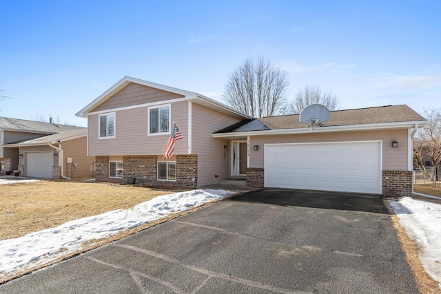 tri-level home featuring brick siding, driveway, and an attached garage