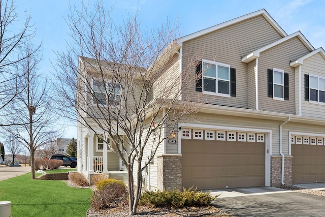 view of front of home featuring brick siding, driveway, a front yard, and a garage