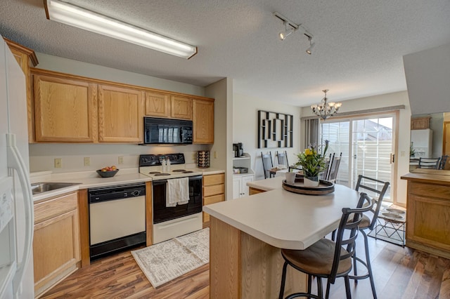 kitchen with light wood-style flooring, a kitchen island, electric range oven, white dishwasher, and black microwave