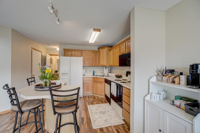 kitchen with electric range, white fridge with ice dispenser, black microwave, light wood finished floors, and dishwashing machine