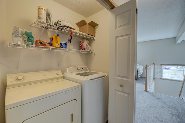 laundry room with carpet flooring, separate washer and dryer, laundry area, and a textured ceiling