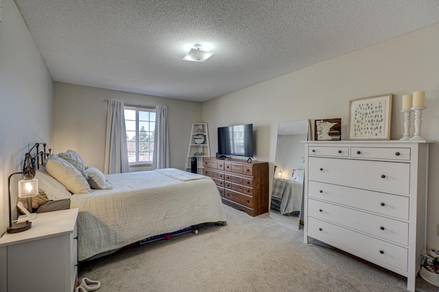 bedroom featuring light carpet and a textured ceiling