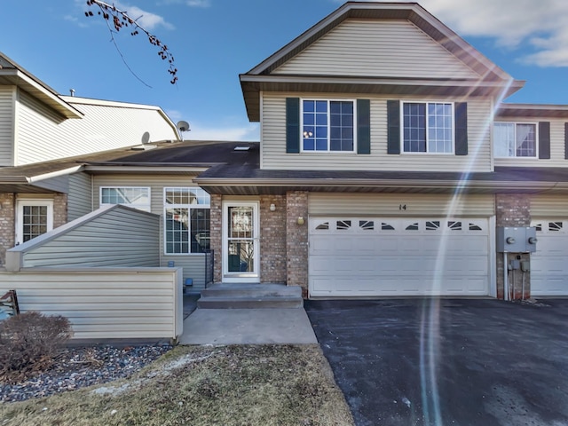 view of front of home with brick siding, driveway, and a garage