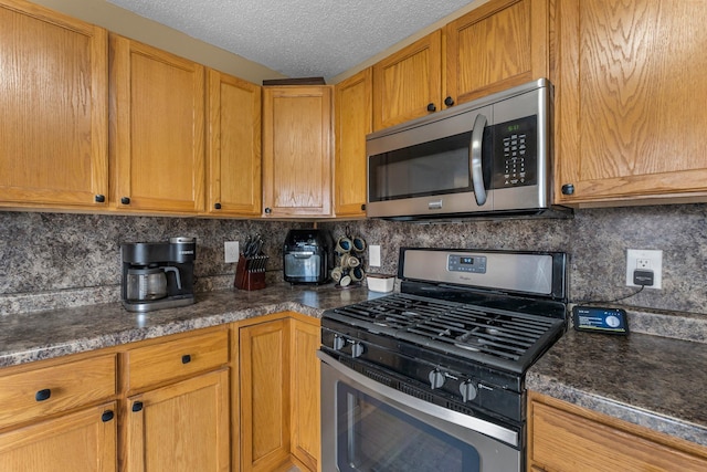 kitchen featuring brown cabinets, tasteful backsplash, appliances with stainless steel finishes, and a textured ceiling