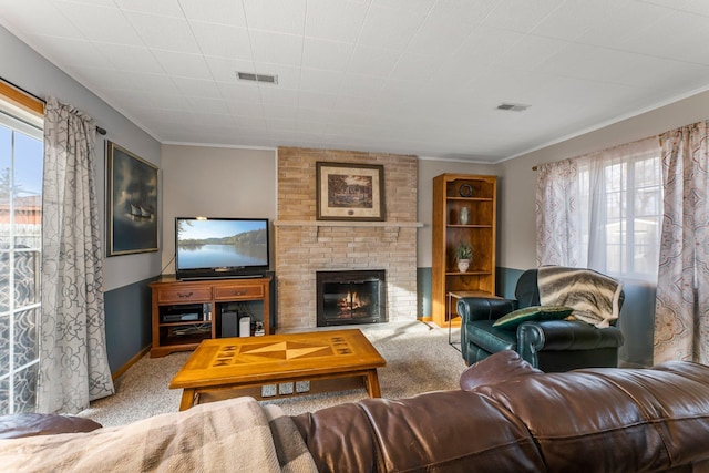 carpeted living area with a brick fireplace, baseboards, visible vents, and ornamental molding