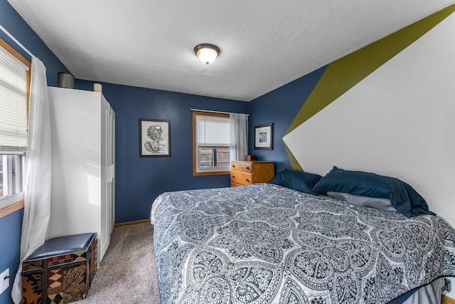 carpeted bedroom with multiple windows, baseboards, and a textured ceiling