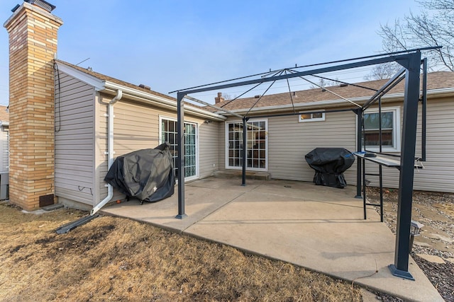 rear view of house featuring a patio area and a chimney