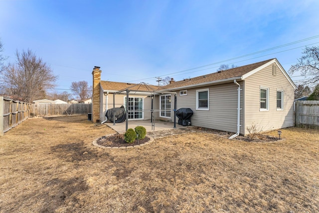 back of property with a lawn, a fenced backyard, and a patio area