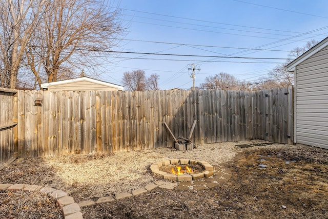 view of yard featuring an outdoor fire pit and fence