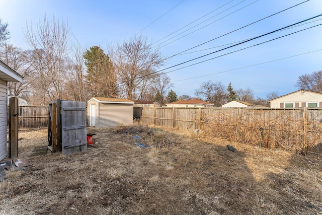 view of yard with an outdoor structure, a storage shed, and a fenced backyard