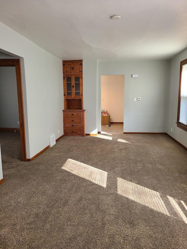 unfurnished room featuring visible vents, baseboards, and carpet floors