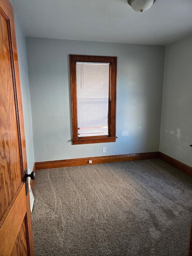 spare room featuring baseboards and carpet floors