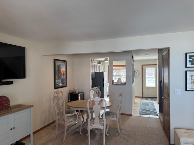 dining space with light colored carpet and baseboards