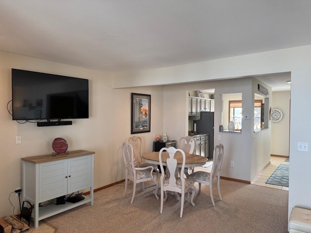 dining area featuring baseboards and light colored carpet