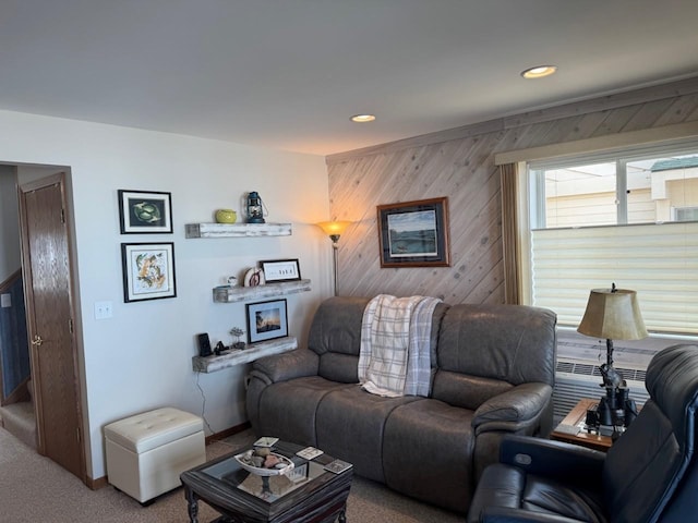 carpeted living room featuring wooden walls and recessed lighting