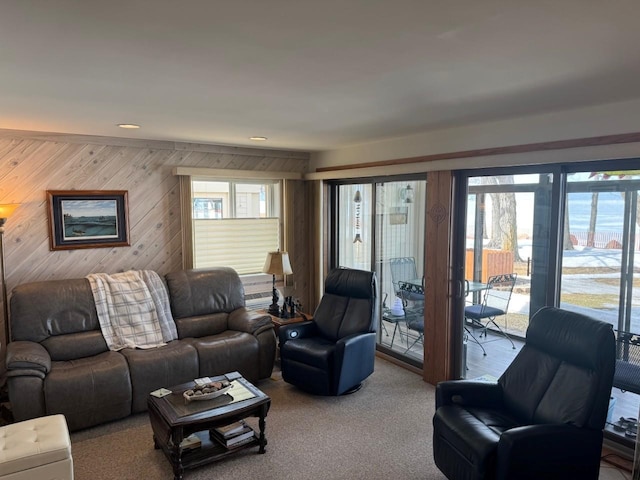 carpeted living area with wooden walls