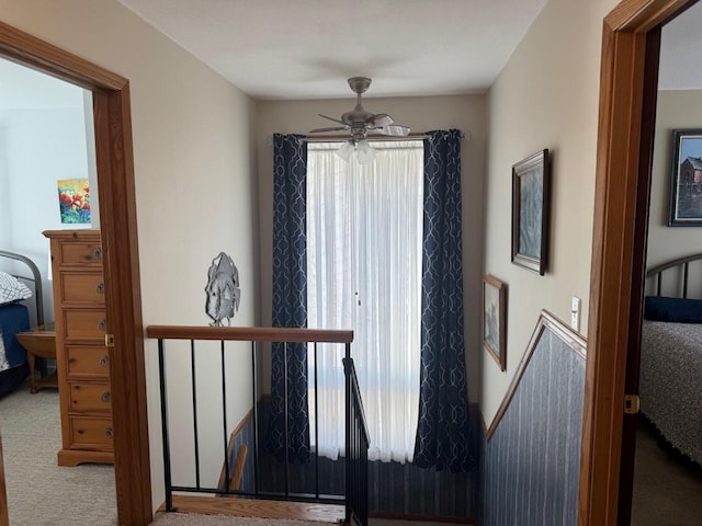 stairway with carpet flooring and a ceiling fan