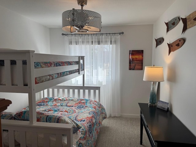 carpeted bedroom with baseboards and an inviting chandelier