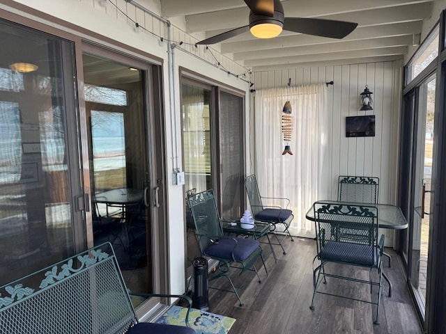 sunroom / solarium featuring beam ceiling and ceiling fan