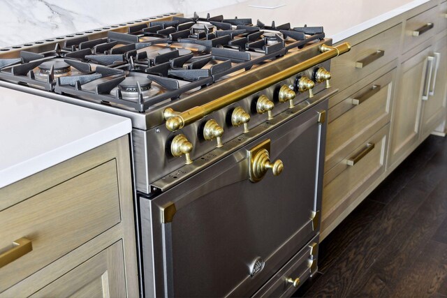 room details featuring dark wood finished floors, high end stove, and tasteful backsplash