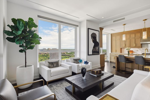 living area featuring visible vents, baseboards, and dark wood-style flooring