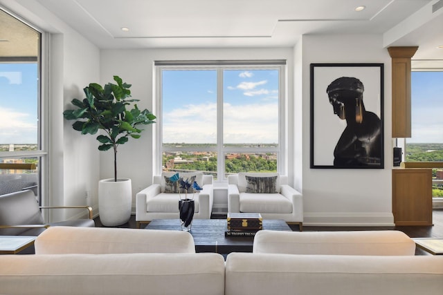 living room featuring visible vents, baseboards, recessed lighting, wood finished floors, and ornate columns