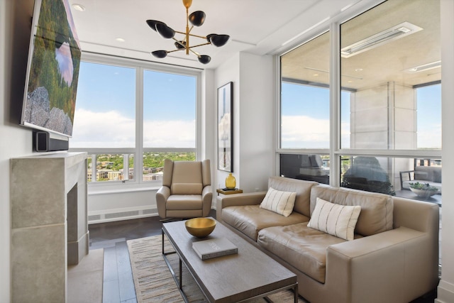 living area featuring an inviting chandelier, wood finished floors, and baseboards