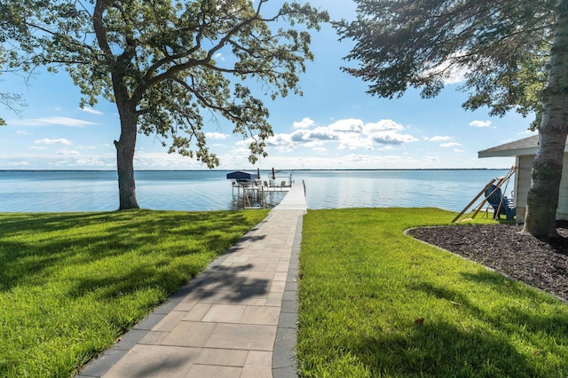 view of dock with boat lift, a yard, and a water view