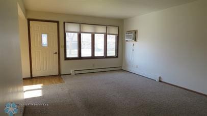 carpeted entryway with a baseboard heating unit