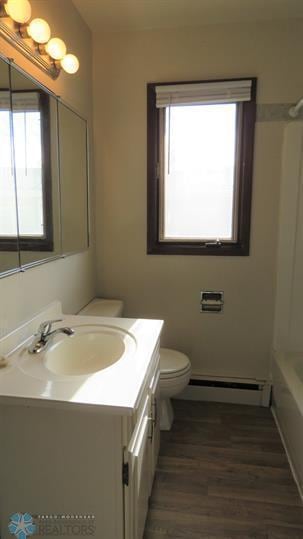 bathroom with plenty of natural light, toilet, vanity, and a baseboard radiator