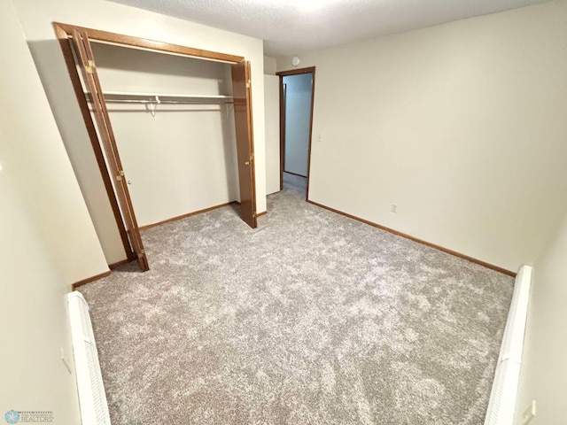 unfurnished bedroom with a closet, baseboards, a textured ceiling, and carpet flooring