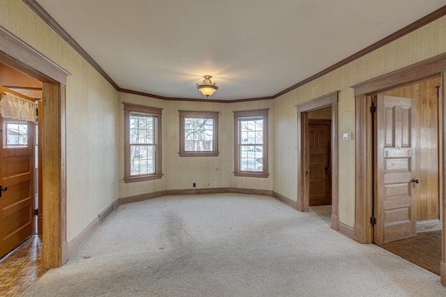 unfurnished room with baseboards, light carpet, visible vents, and ornamental molding