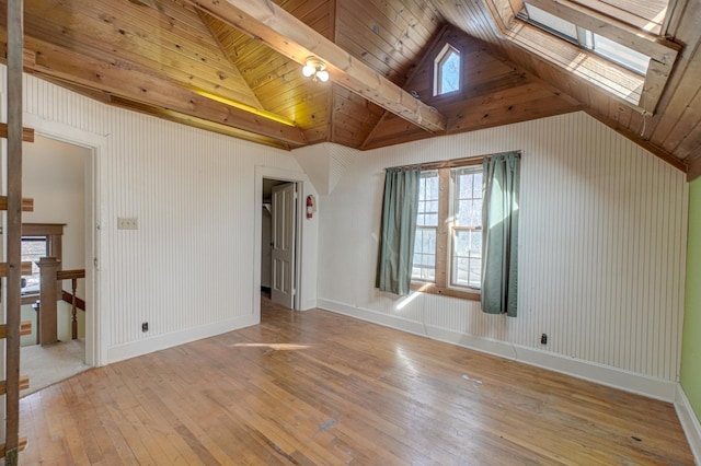 interior space featuring a skylight, plenty of natural light, baseboards, and light wood finished floors