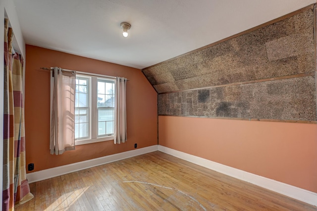 bonus room featuring lofted ceiling, baseboards, and light wood finished floors