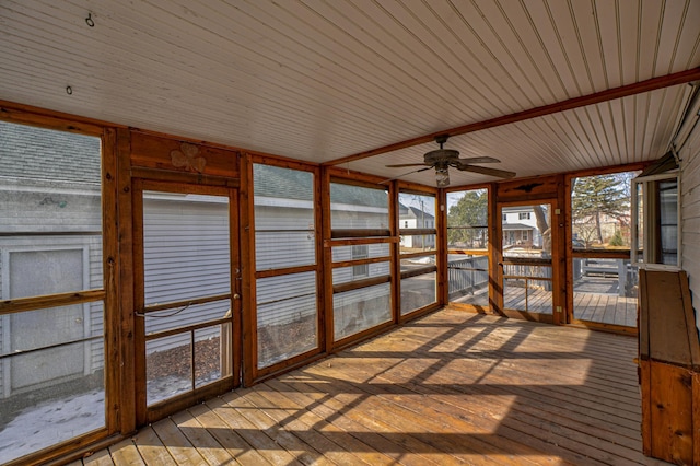 unfurnished sunroom featuring a ceiling fan