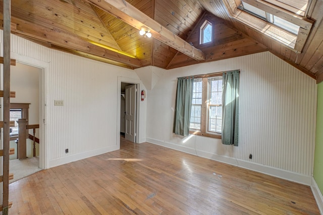 interior space featuring wood ceiling, a skylight, light wood-type flooring, and baseboards