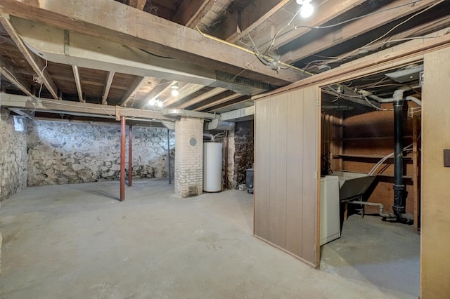 unfinished basement featuring washer / clothes dryer and water heater