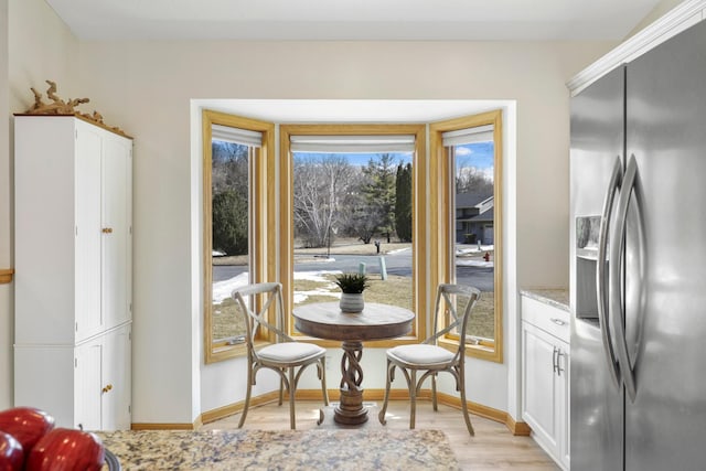 dining space with baseboards and light wood-style floors