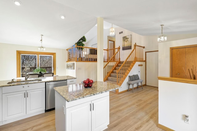 kitchen with a notable chandelier, white cabinets, dishwasher, and vaulted ceiling