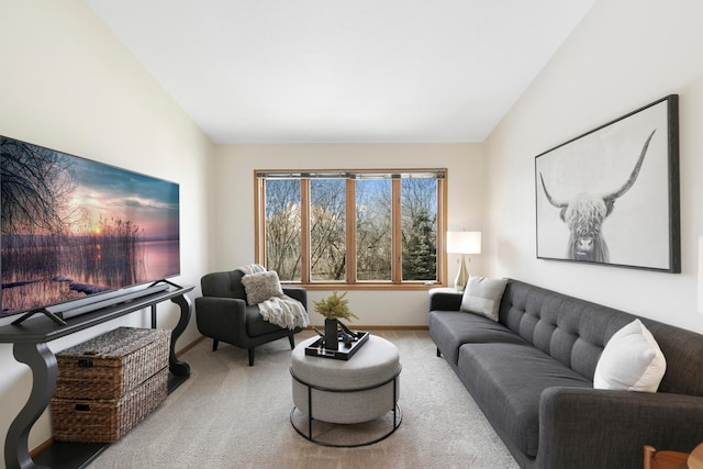 carpeted living area featuring baseboards and vaulted ceiling